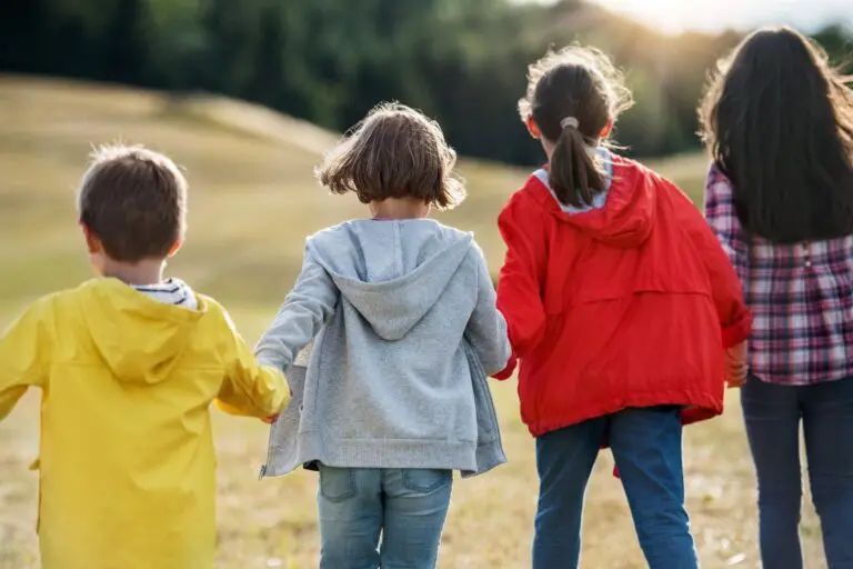 Four children walking away from the camera.