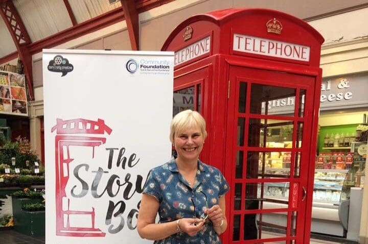 Kath from Remembering the Past standing in front of a red telephone box