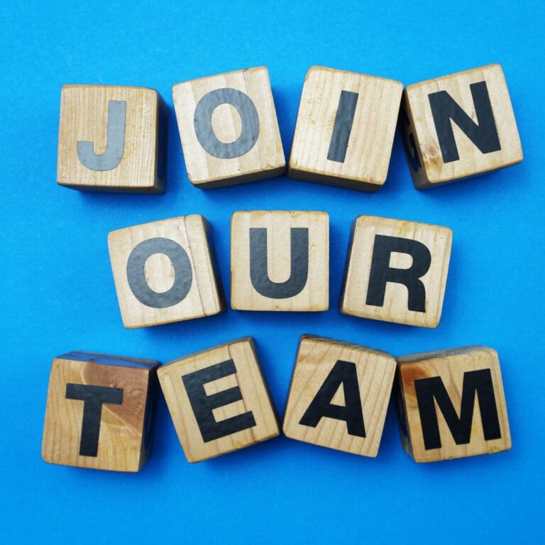 Join our team written in wooden blocks on a blue background