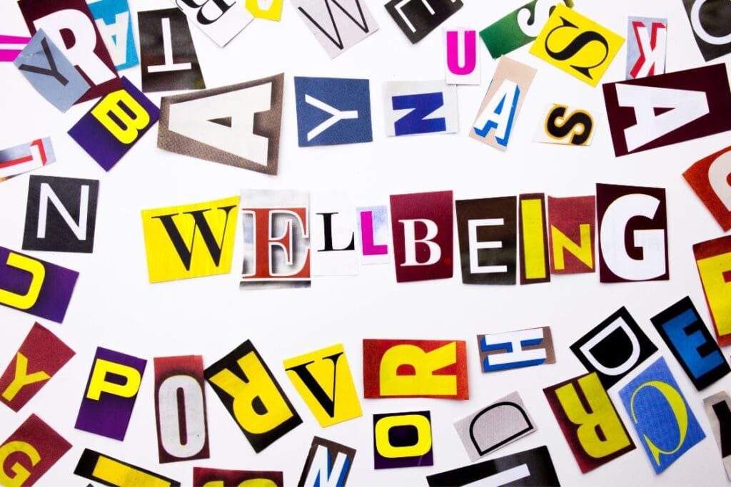 The word WELLBEING spelled out in cut out letters from a magazine