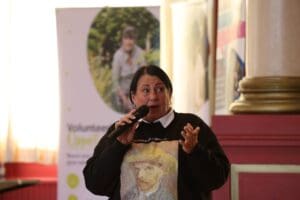 Person with microphone wearing black jumper.