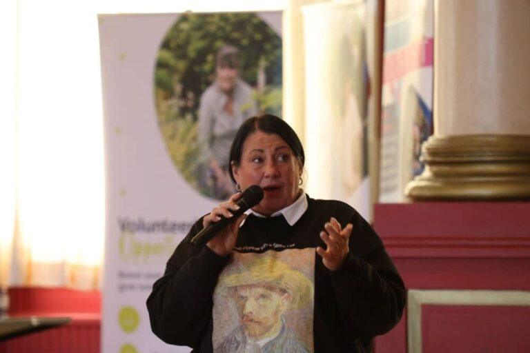 Person with microphone wearing black jumper.