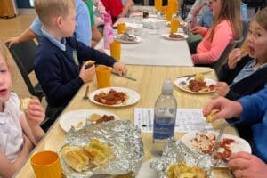 Table full of food, with children eating