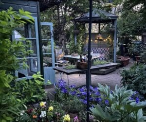 A picturesque garden featuring a gazebo surrounded by a variety of colorful flowers, lush greenery, and well-maintained landscaping.