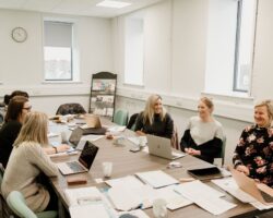 A group sat round a large table covered in papers.