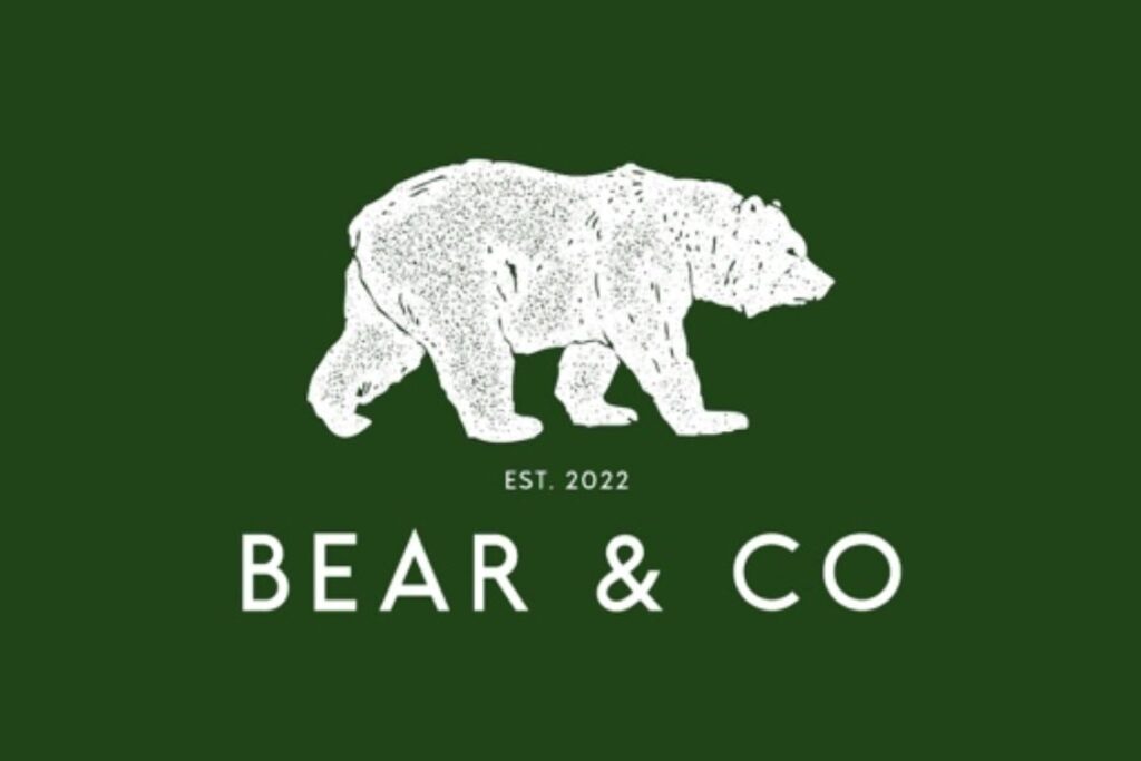 White bear on green background with works Bear & Co