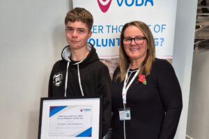 Young Volunteer Taylor Buckley accepting his award from Vicky Smith