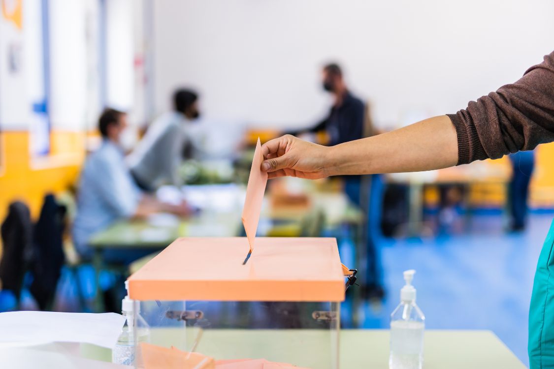 Hand Putting Ballot into a Container
