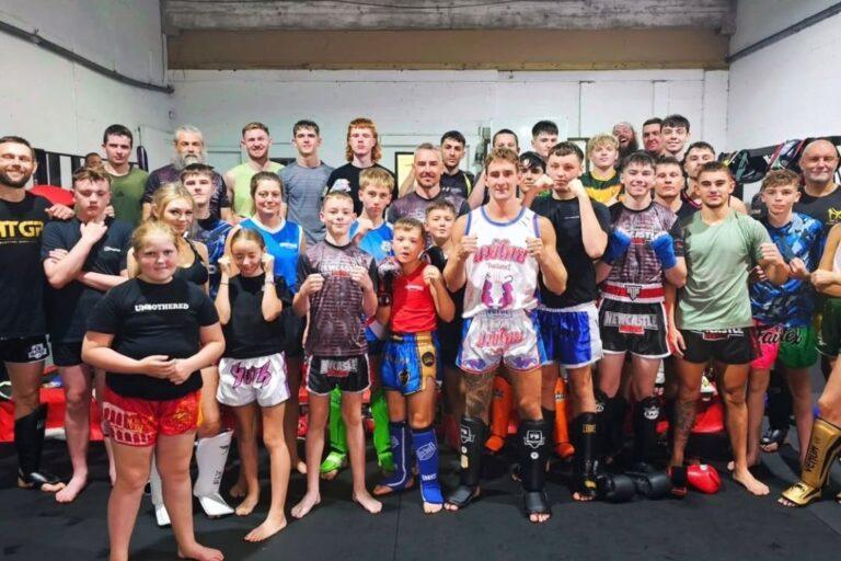 A mixed group of children and adults all in their Thai Boxing kit