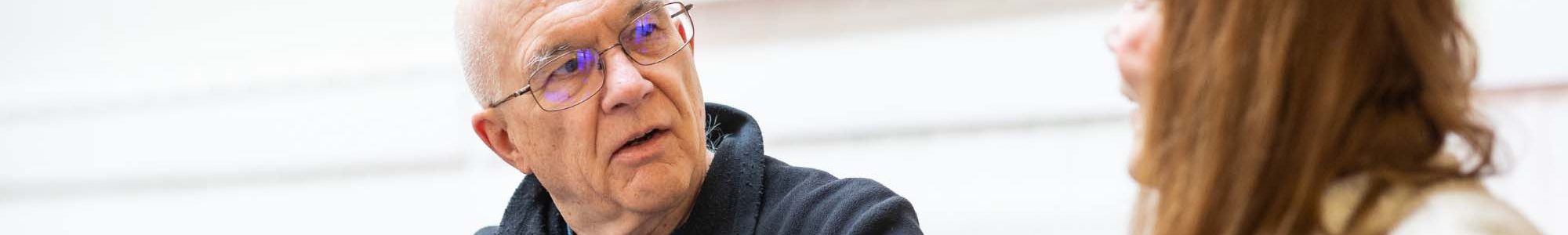 Man with glasses talking to woman