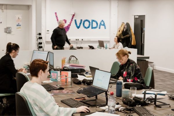 VODA staff in action with logo in background